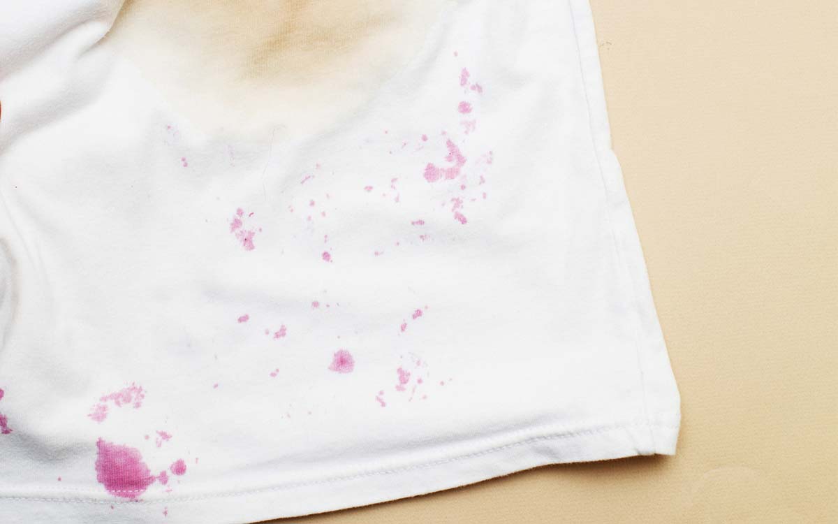 Hvit t-skjorte med flekker som må fjernes.
