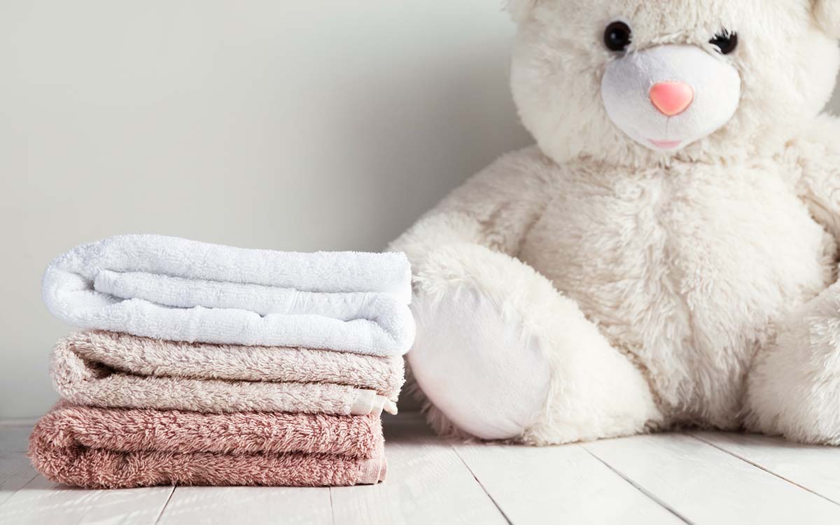 Myke håndklær og bamse som har blitt vasket med tøymykner.
